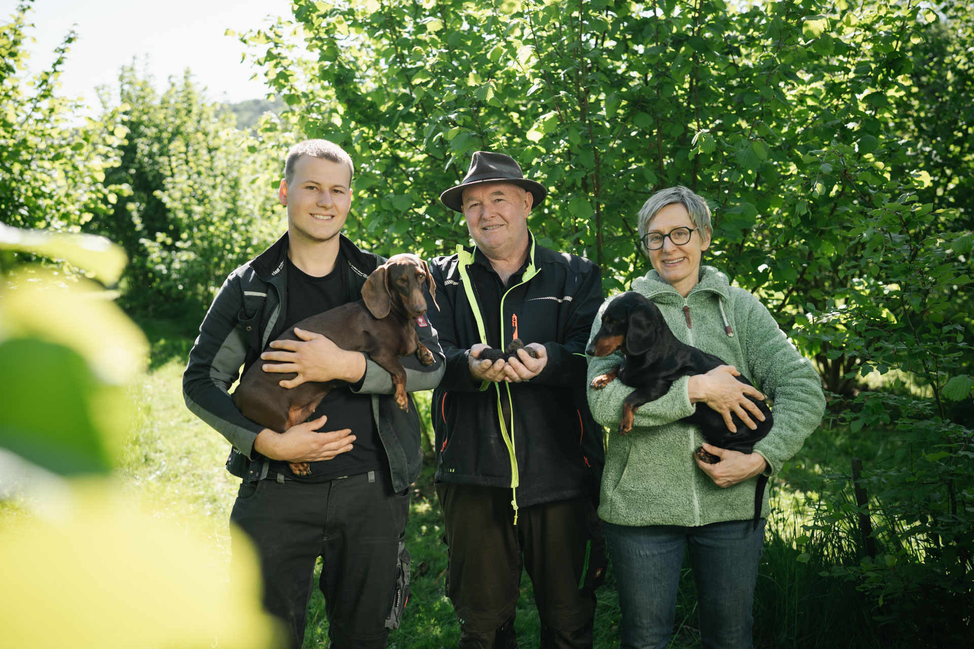 Familie Hofmann mit Trüffelhunden und geernteten Trüffeln in der Plantage